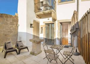un patio con sillas, una mesa y una sombrilla en oldcity design apartments, en Oporto