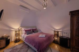 1 dormitorio con 1 cama grande con manta morada en Butik Design Nádas, en Abádszalók