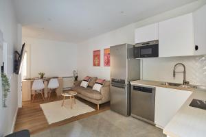 a kitchen and a living room with a couch at Apartment Parc des expositions by Studio prestige in Paris