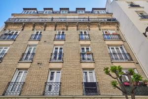 a tall brick building with windows and balconies at Apartment Parc des expositions by Studio prestige in Paris