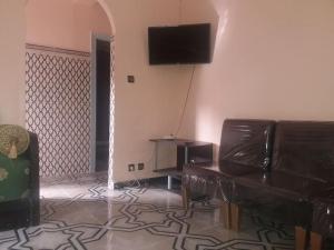 ein Wohnzimmer mit einem Sofa und einem Flachbild-TV in der Unterkunft Oisis Mazagan 2 in El Jadida