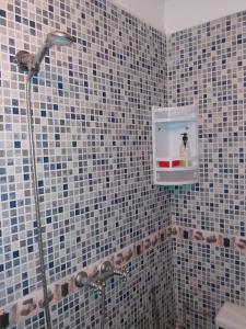 ein Bad mit einer Dusche mit einer Flasche in der Unterkunft Oisis Mazagan 2 in El Jadida