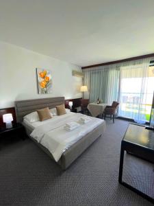een hotelkamer met een groot bed en een groot raam bij CORPUS A - Hotel Albatros in Ulcinj