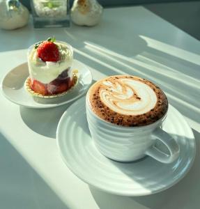 eine Tasse Kaffee und ein Dessert auf dem Tisch in der Unterkunft Me and Tree Villa in Kaeng Khoi