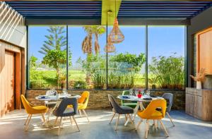 un patio con mesas, sillas y ventanas grandes en Pullman Mazagan Royal Golf & Spa en El Jadida