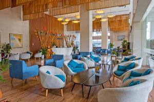 峴港的住宿－Royal Lotus Hotel Danang，大堂设有蓝色的椅子和桌子。