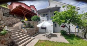 a white umbrella sitting outside of a house at Mini Garsonjera in Podgorica