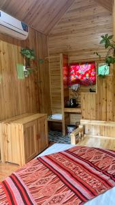 Habitación con paredes de madera y cama con alfombra. en Nobita Homestay bắc hà, en Bắc Hà