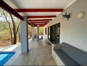 a patio with a couch and a swimming pool at Bushbuck Rest in Marloth Park