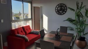 uma sala de estar com um sofá vermelho e uma mesa em Sortie - Rio em Rosário