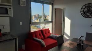 Sofá rojo sentado en una habitación con ventana en Sortie - Rio en Rosario