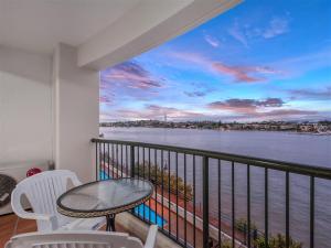 balcón con mesa, sillas y vistas al agua en Goldsborough Place Apartments en Brisbane