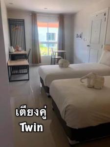 a hotel room with two beds and a window at Me and Tree Villa in Kaeng Khoi