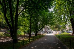 a street in a park with trees and a fence at Grand Park Hotel in Szczecin