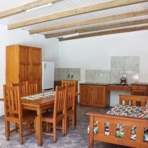 a room with a table and chairs and a kitchen at Kosi Bay Lodge in Manguzi