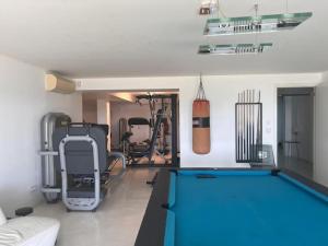 Modern Villa with Sea & River View Pool and Gym. في لشبونة: صالة رياضية مع طاولة بلياردو و معدات ممارسة الرياضة