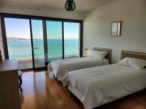 2 łóżka w pokoju z widokiem na ocean w obiekcie Modern Villa with Sea & River View Pool and Gym. w Lizbonie