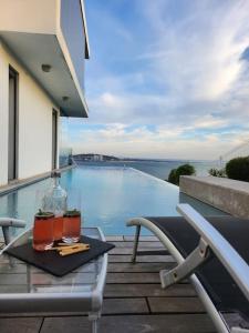 uma mesa com duas bebidas em cima de uma varanda em Modern Villa with Sea & River View Pool and Gym. em Lisboa