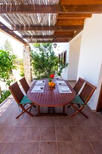 Villa Pomos Med. في بوموس: طاولة وكراسي خشبية على الفناء
