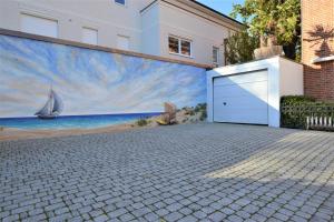 ein Gebäude mit einem Gemälde eines Strandes und einer Garage in der Unterkunft Moderne Kurparkresidenz in Timmendorfer Strand