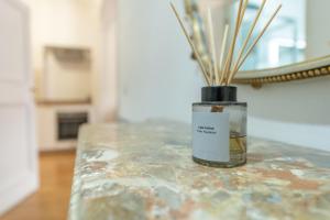 Un frasco con palos dentro, colocado sobre una mesa. en Palazzo Pamphili Lecca di Guevara, en Roma 61 fotos más