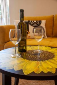 a bottle of wine and two wine glasses on a table at Apartments Katarina Porat in Malinska