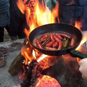 a pan of hot dogs cooking on a fire at Orange Elephant Backpackers in Addo