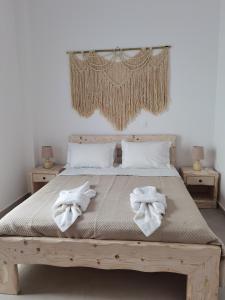 a bedroom with a wooden bed with towels on it at Villa Konstantinos in Perissa