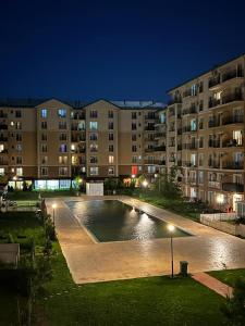 a swimming pool in front of a building at night at Cosmopolis Single Bedroom Apartment 204 in Creţuleasca
