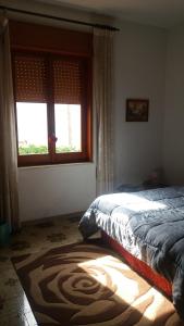 a bedroom with a bed and a window and a rug at Casa Bianca da Giusy in Birgi Vecchi