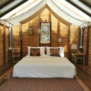 a bedroom with a large bed in a tent at THE RIVER RUNS CHIANG KLANG in Chiang Klang