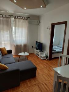 a living room with a couch and a mirror at Smiley 2 - Subotica Centar in Subotica