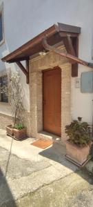 un edificio con una puerta marrón y dos plantas en Casa Vacanze Angelo, en Ortona