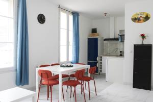 eine Küche mit einem weißen Tisch und roten Stühlen in der Unterkunft Newly renovated cocoon with terrace near the Seine in Ivry-sur-Seine