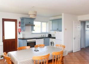 a kitchen with a table and chairs in a kitchen at Ballybunion Holiday Cottage No 10 in Ballybunion