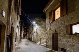 eine Gasse in der Nacht mit Lichtern an den Gebäuden in der Unterkunft A de Calón in Marín