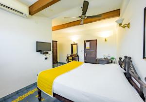 um quarto com uma cama e uma ventoinha de tecto em Bloom Boutique Waterfront Fort Kochi em Cochin