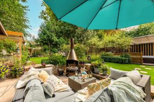 a patio with a couch and an umbrella at Newmarket Boutique Apartments in Newmarket