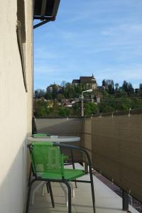 una sedia verde seduta su un balcone con vista di Marko’s apartament a Sighişoara