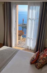 a bedroom with a window with a view of the ocean at Hôtel Des Gouverneurs in Bastia