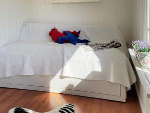 a red and blue stuffed animal sitting on a bed at Holiday home HJO IV in Hjo