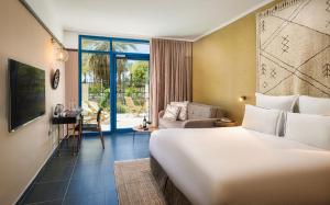 a hotel room with a bed and a living room at Brown Red Sea - Central Park in Eilat