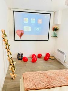 a room with a projection screen and red balls on the floor at Maison vue sur mer in Bretteville