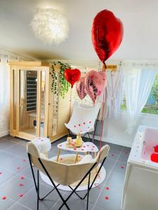 una habitación con globos y una mesa con un pastel y globos en Maison vue sur mer, en Bretteville