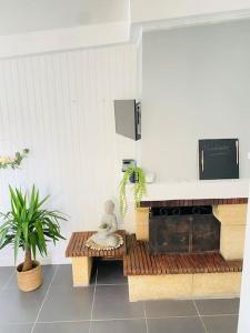 a kitchen with a stove and a bench with a plant at Maison vue sur mer in Bretteville