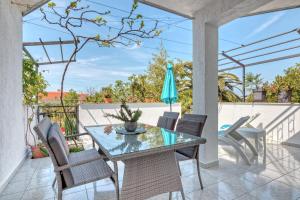 a patio with a glass table and chairs at Apartments Birimac in Pula