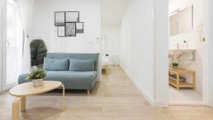 a living room with a blue couch and a table at Apartamentos Dimax by Toledo AP in Toledo