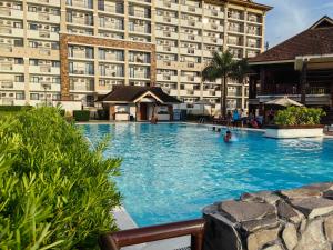 a swimming pool in front of a large building at MQ Staycation at One Oasis in Cagayan de Oro