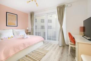 um quarto com uma cama rosa e uma janela em 5Min to Liberty Bridge-Free parking-Lovely Home. em Budapeste