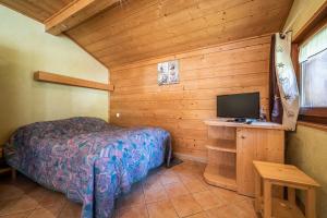 a bedroom with a bed and a television in a cabin at Apt Chénives 1 - Morzine in Morzine